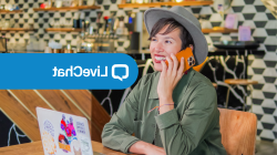 March Livechat image. A lady smiling while on the phone in front of her laptop